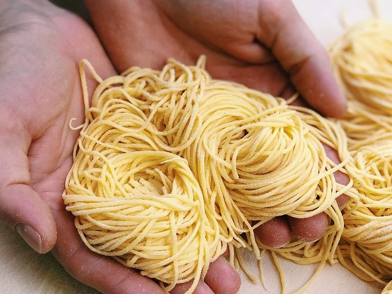Fresh pasta held in two open hands