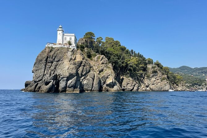 A white lighthouse on a rocky point, seen from the sea